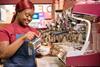 Costa employee pouring frothy milk into a mug