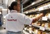 A worker stocks a chiller with sandwiches at a Pret shop in the US  2100x1400