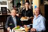 TCG director of operations Ben Levick (left) and chief operating officer Nigel Wright (right) are served a Sunday Roast at the Hop Poles in Hammersmith by team member Simona Pane