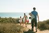 Family walking to beach - stock photo