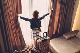 Tourist woman just arriving in the hotel room - stock photo