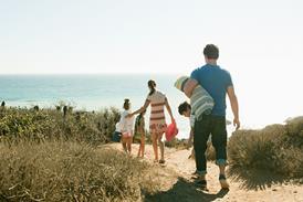 Family walking to beach - stock photo