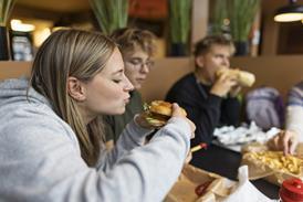 Teens eating in restaurant Getty