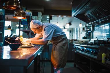 Hospitality worker in kitchen GettyImages-1158191245