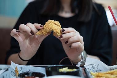 Woman eating fried chicken - Getty STOCK