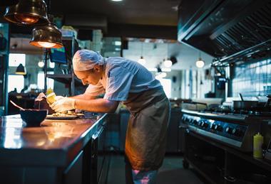 Hospitality worker in kitchen GettyImages-1158191245