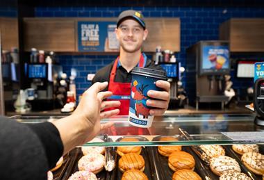 Greggs - Worker serves a coffee to a customer during the festive period