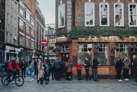 Facade of The Blue Posts pub in Soho, London, UK, people outside, motion blur. - stock photo